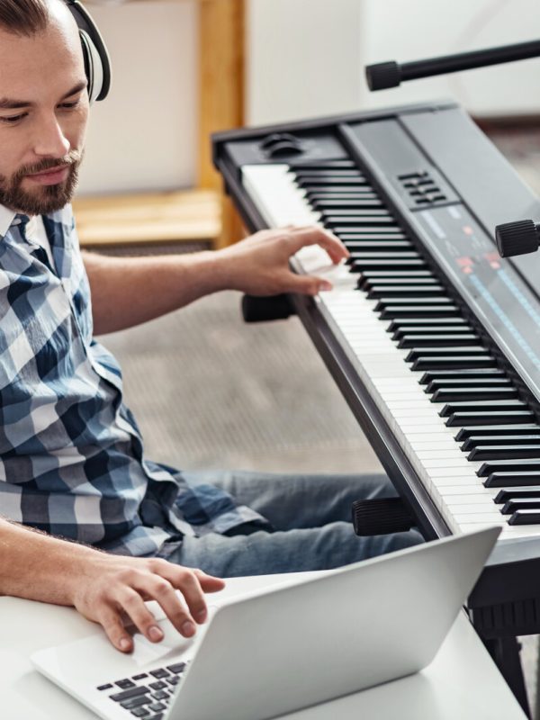 Disable musician checking out new material Those might make it into a song. Devoted handsome incapacitated man looking through recently recorded tracks and editing them while using his laptop and sitting in his own home studio